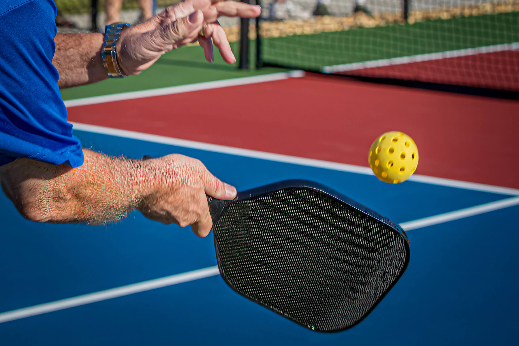 Over,The,Shoulder,Shot,Of,Man,Hitting,A,Pickleball,With